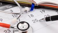 Close up of stethoscope and pen on calendar, doctor appointment.